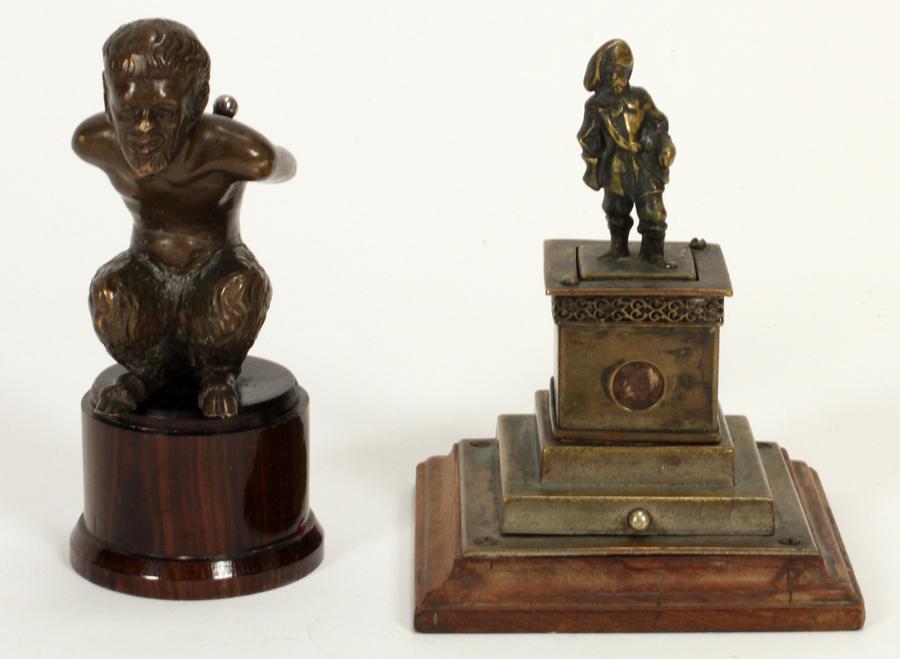 FIGURAL BRONZE CIGAR CUTTERS, 2 PCS: FIGURAL BRONZE CIGAR CUTTERS, 2 PCS, H 4" & 4 1/2" One depicts a bronze figure of a man on a wood plinth. The cutter rises out of his back, 4 1/2" H. The second is an old European bronze cutter statue
