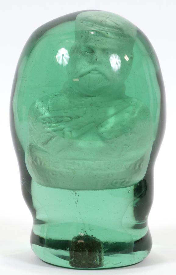 EDWARD VII GREEN BLOWN GLASS AND SULPHIDE DOORSTOP: EDWARD VII GREEN BLOWN GLASS AND SULPHIDE DOORSTOP, 1902 H 7" Hand blown green glass paperweight or doorstop with interior sulphide bust of King Edward VII, Dia. 4.5".