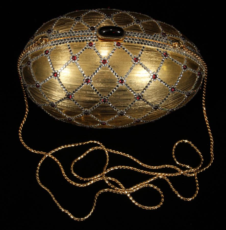 JUDITH LEIBER SWAROVSKI CRYSTAL, METAL MINAUDIERE: JUDITH LEIBER FABERGE EGG FORM SWAROVSKI CRYSTAL, METAL MINAUDIERE H 3.5" L 6" Having a jeweled clasp. Lined with gold leather. No box. Having a jeweled clasp. Lined with gold leather. No box.