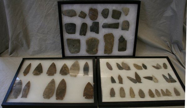 AMERICAN SPEAR HEADS, TOOLS & ARROW HEADS: AMERICAN CARVED STONE SPEAR HEADS, TOOLS & ARROW HEADS, 51 PCS., L 1 1/2" - 5":51 carved arrow heads, spear heads and tools some with holes cut into their centers all mounted in three glass lid displa