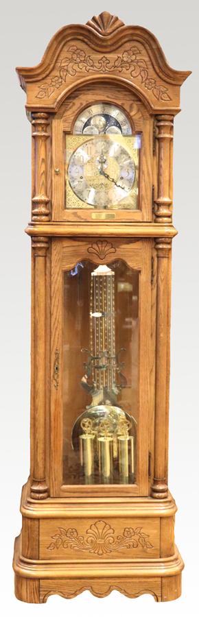 HOWARD MILLER GRANDFATHER CLOCK H 85": HOWARD MILLER GRANDFATHER CLOCK H 85", W 25", D 16" Howard Miller grandfather clock. Having an arched pediment above a framed glass access door flanked by two half-round columns and opens to a polishe