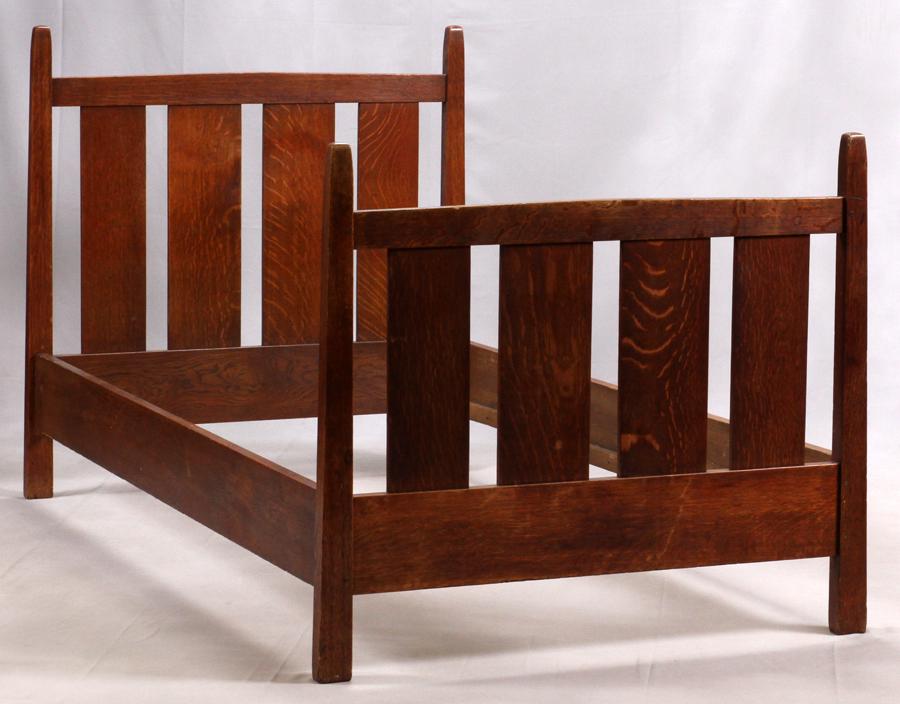 GUSTAV STICKLEY TWIN OAK BED FRAME: GUSTAV STICKLEY TWIN OAK BED FRAME H 46" W 46" L 78" A Gustav Stickley twin bed with four vertical slats under a rail and toe-board. Slats included. Interior width: 42". Marked 'ALS'.