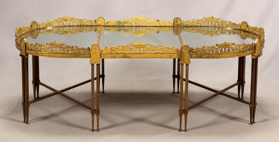 FRENCH GILT BRONZE & GLASS TABLE: FRENCH GILT BRONZE & GLASS SURTOUT DE TABLE, NOW COCKTAIL TABLE H 21", L NOW 58.5", L 78" WITH 4TH SECTION, D 26" Having a cast and gilt bronze ormolu gallery and a glass surface. Having a removable l