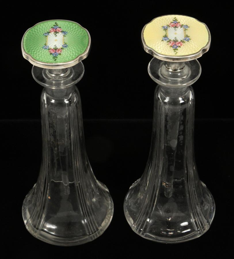 ENAMEL, STERLING, CRYSTAL PERFUME BOTTLES C. 1920: ART DECO PERIOD ENAMEL, STERLING, CRYSTAL PERFUME BOTTLES, C. 1920, PAIR H 6" Sterling stoppers with inset yellow and green engine-turned floral enamel decoration, set in floral etched crystal bases. 
