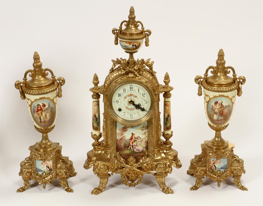 IMPERIAL, GILT METAL & PORCELAIN, GARNITURE SET: IMPERIAL, ITALY, GILT METAL & PORCELAIN, GARNITURE SET, MID TO LATE 20TH. 3 PCS. H 13"-16", W 5"-9"The clock has roman numerals on the face and measures, height 16", width 9", and depth 5.5". The urns