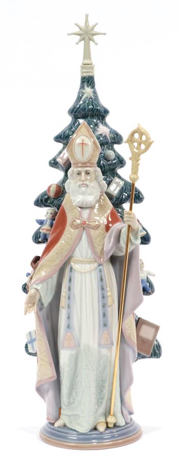 LLADRO PORCELAIN FIGURINE, SAINT NICHOLAS: LLADRO PORCELAIN FIGURINE, H 16" W 5" SAINT NICHOLAS Standing figurine of St. Nicholas in front of a Christmas tree.