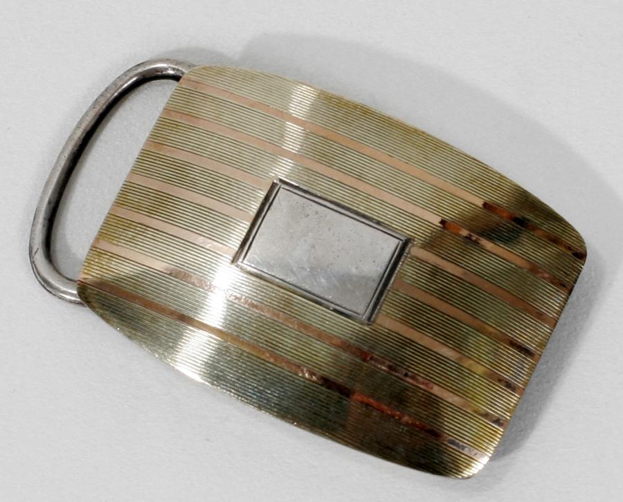 AMERICAN STERLING SILVER & GOLD PLATED BELT BUCKLE: AMERICAN STERLING SILVER & GOLD PLATED BELT BUCKLE C 1920 L 2 1/4" Engine turned linear motif. Unidentified trade mark: S with BM. patent 1915. No monogram.