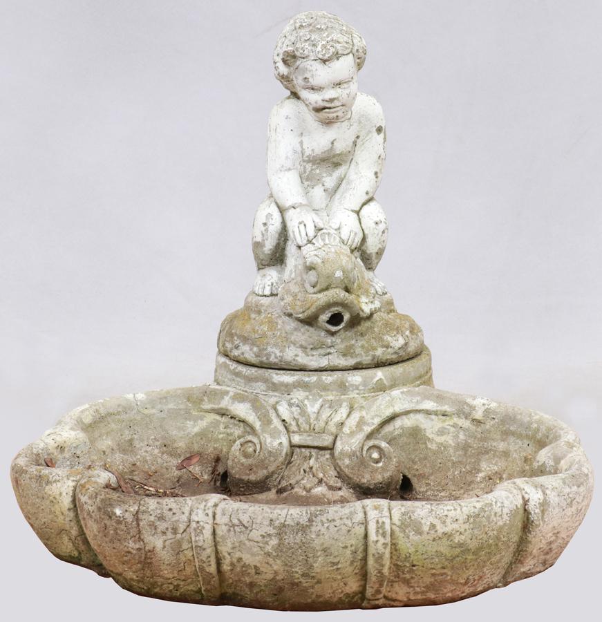 BOY ON DOLPHIN CEMENT GARDEN SCULPTURE: BOY ON DOLPHIN CEMENT GARDEN SCULPTURE, H 15", DIA 9" A cast cement garden sculpture depicting a boy on a dolphin.