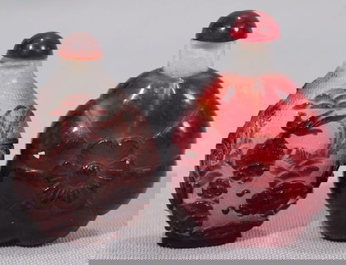 CHINESE CARVED PEKING GLASS SNUFF BOTTLES, 2, H: CHINESE CARVED RED AND BROWN PEKING GLASS SNUFF BOTTLES, 2, H 2 3/4", 2 1/2"Red bottle having a ribbed design with a central flower; brown having aquatic fish design carved to crosshatched clear.