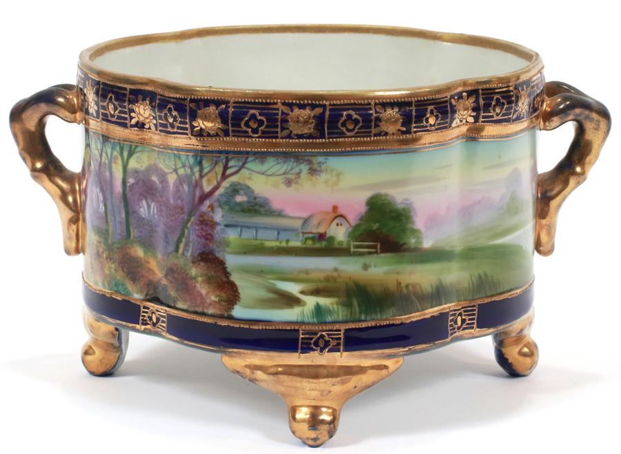 NIPPON PORCELAIN HAND PAINTED PLANTER, CIRCA 1900: NIPPON PORCELAIN HAND PAINTED PLANTER, CIRCA 1900 H 5.75", L 10.5"A hand-decorated Nippon porcelain footed planter. Having branch form handles, scenes of pastoral landscapes to the perimeter accented 
