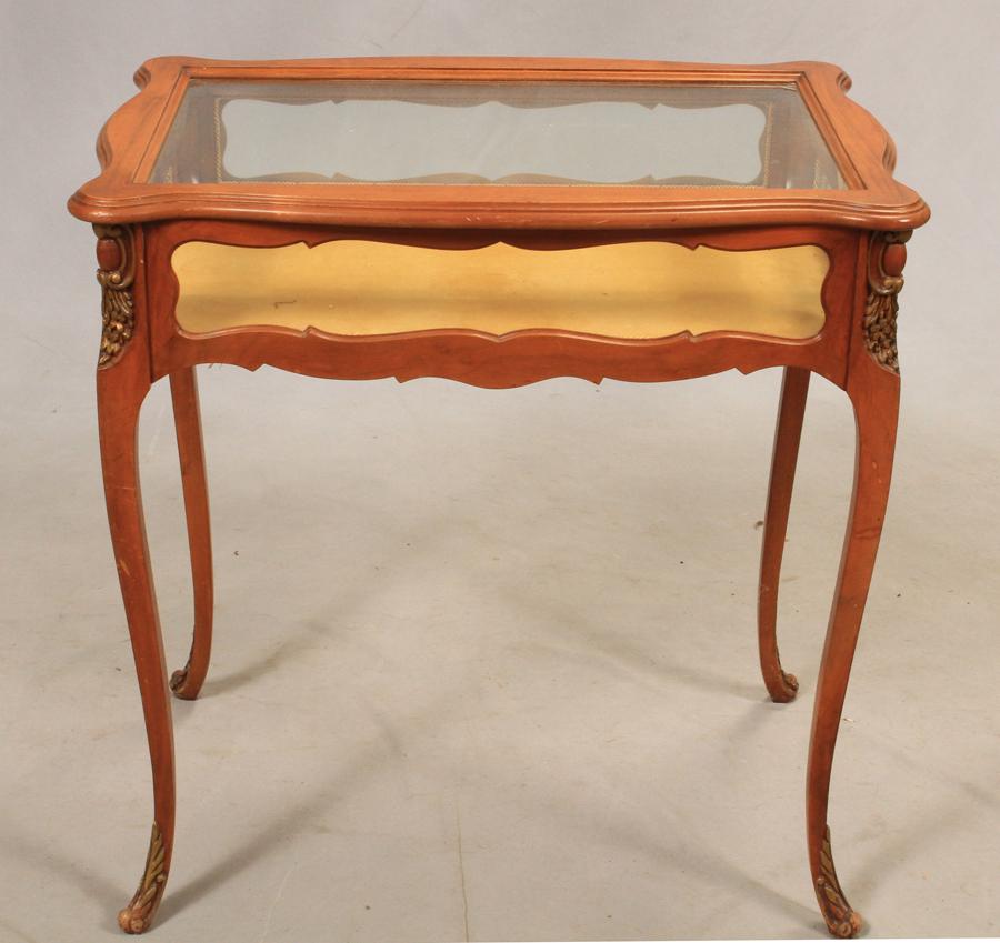 FRENCH STYLE WALNUT CURIO TABLE H 31" W 29": FRENCH STYLE WALNUT CURIO TABLE H 31" W 29" Beveled glass, Carved wood detail. From an Arbor Court, Bloomfield Hills estate.