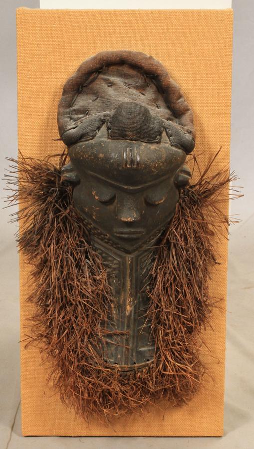 AFRICAN CARVED WOOD MASK, H 21", W 10": AFRICAN CARVED WOOD MASK, H 21", W 10" An African carved wood mask. Mounted on burlap lined backboard, measuring H 27" x L 13".