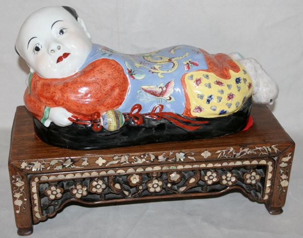 CHINESE PORCELAIN FIGURE, YOUNG BOY, H 6 1/2": CHINESE PORCELAIN FIGURE, YOUNG BOY, H 6 1/2", W 5 1/2", L 14 1/2":depicts a reclining young boy on a stand with inset mother of pearl floral designs. From the Estate of Robert D. Ellinger, Grand Rapi