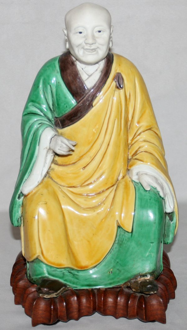 CHINESE MUD FIGURE OF A SEATED MAN, C. 1940: CHINESE MUD FIGURE OF A SEATED MAN, C. 1940, H 10 1/2", W 6":bright yellow and green robe with brown trim; on a fitted wooden stand. Unmarked. From the Estate of Robert D. Ellinger, Grand Rapids, MI.