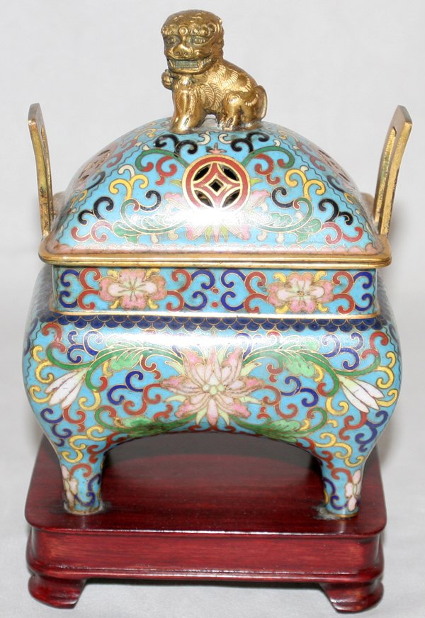 CHINESE CLOISONNÉ COVERED URN, H 8", W 4 1/2": CHINESE CLOISONNÉ COVERED URN, H 8", W 4 1/2":rectangular urn with lid with gilt foo lion finial, gilt trim. Four feet with blue, green, red, yellow and pink vine and floral designs; rectangular wood