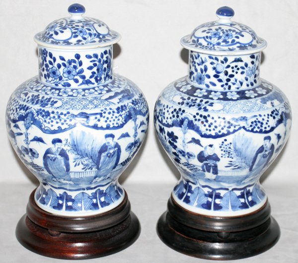 CHINESE GINGER JARS, PAIR, H 9", DIA 7": "CHINESE GINGER JARS, PAIR, H 9"", DIA 7"":With blue under glaze marks, finials on lids and wood bases. Lid on one jar is chipped. From the Estate of Robert D. Ellinger, Grand Rapids, MI." (rev.200903
