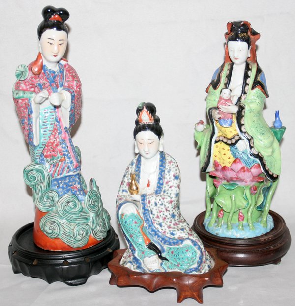 CHINESE PORCELAIN FIGURINES, THREE: CHINESE PORCELAIN FIGURINES, THREE:One seated figure of Quan Yin, H 6 1/2"; one female figure holding a child, H 9"; and one female figure, H 10"; with wood stands. From the Estate of Robert D. Elling