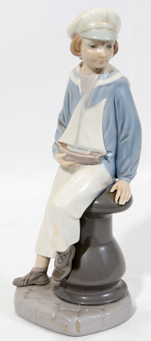 LLADRO FIGURE, 'BOY WITH YACHT', #4810, H 9": LLADRO FIGURE, 'BOY WITH YACHT', #4810, H 9":Porcelain figure of a boy holding a toy boat, number 4810.