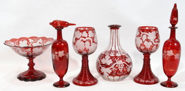 BOHEMIAN ETCHED RUBY GLASS WARE, SIX PIECES: BOHEMIAN ETCHED RUBY GLASS WARE, SIX PIECES:Including 2 Rhine wines, H.7", 1 compote, H.5", Dia.6 3/4" (a 1/4" chip under the rim), and 2 cologne bottles, H.10 1/2" (one with stopper broken in the nec