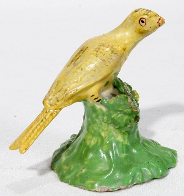 STAFFORDSHIRE CANARY, MANNER OF J. WALTON: STAFFORDSHIRE CANARY, MANNER OF J. WALTON, EARLY 19TH C., H 2":Staffordshire figure of a canary perched on a leafy stump, hand-painted in yellow and green, in the manner of John Walton.