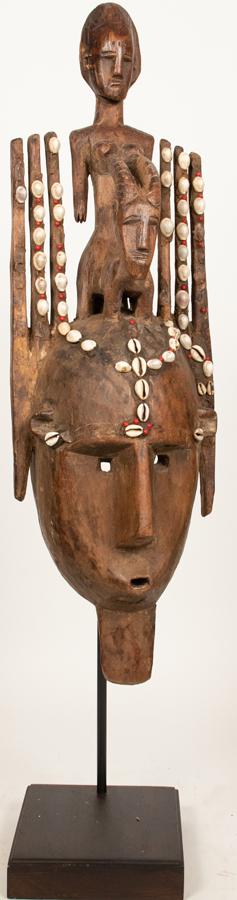 BAMANA, MALI AFRICAN CARVED WOOD, BEADS AND COWRIE: BAMANA, MALI AFRICAN CARVED WOOD, BEADS AND COWRIE SHELLS, NTOMO MASK H 31" W 9" Male Mask with facial hair and six horns centered by nude female riding a goatProvenance: Estate of Jack Faxon, Birming