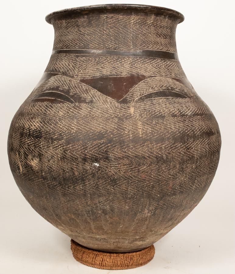 EAST AFRICAN CLAY VESSEL H 24" DIA 24": EAST AFRICAN CLAY VESSEL H 24" DIA 24" Dark clay. Textured and smooth serpent skin pattern, Diameter of opening: 15". Provenance: Estate of Jack Faxon, Michigan Senator, and creator of the Michigan Co