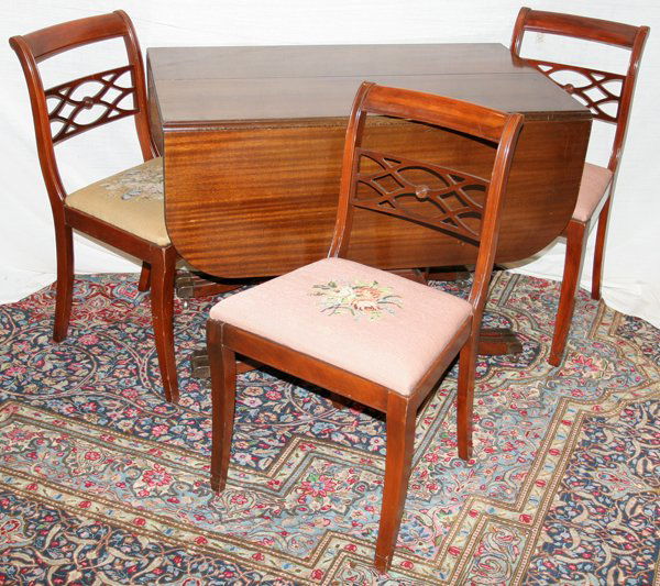 MAHOGANY DROP LEAF TABLE, SIX CHAIRS AND LEAVES: MAHOGANY DROP LEAF TABLE, SIX CHAIRS AND THREE LEAVES:Chairs with needlepoint seats of varying colors. Duncan Phyfe style, circa 1940.