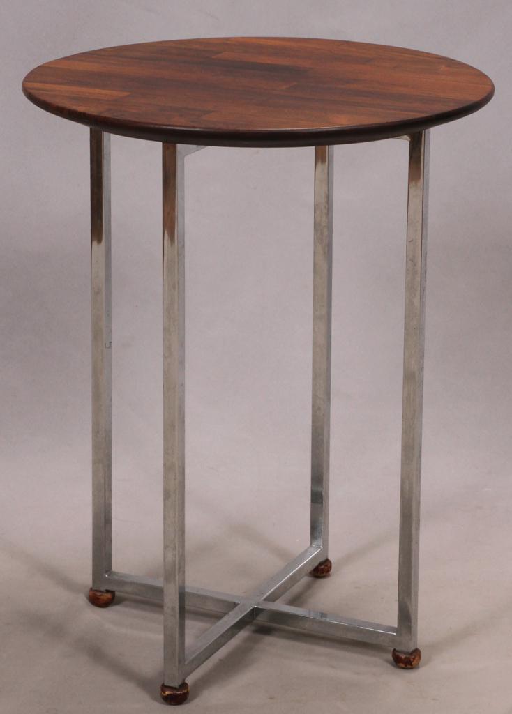 DANISH MODERN ROSEWOOD AND STAINLESS STEEL END TABLE H: DANISH MODERN ROSEWOOD AND STAINLESS STEEL END TABLE H 22" W 18" Circular top with four straight legs on an x-form base. Estate of Jack Faxon, Birmingham, MI. Michigan Senator and creator of the Michi