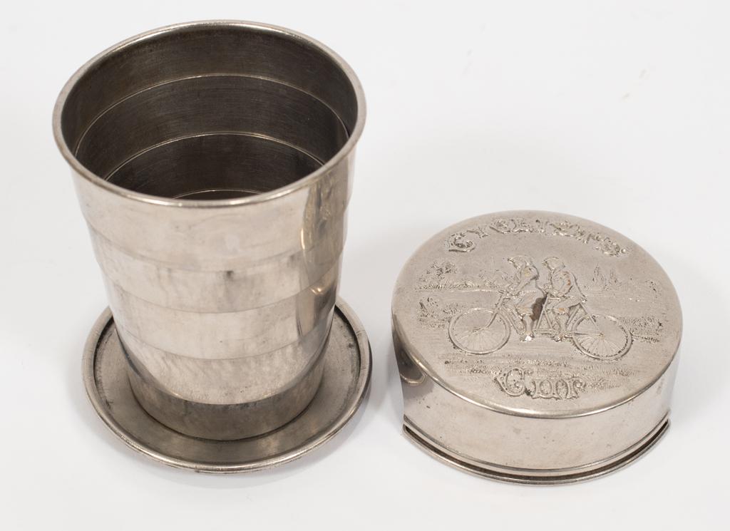 SILVER PLATE COLLAPSIBLE "CYCLIST'S CUP" C. 1900 DIA: SILVER PLATE COLLAPSIBLE "CYCLIST'S CUP" C. 1900 DIA 2.5" Hand chased with a couple riding a tandem bike through the countryside. Titled"Biker's Cup". "Made in USA".