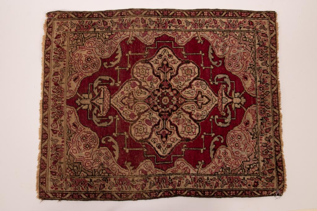 ANTIQUE PERSIAN HAND WOVEN WOOL MAT H 23" W 14.5": ANTIQUE PERSIAN HAND WOVEN WOOL MAT H 23" W 14.5" Central ivory medallion on deep red ground. Urn and floral forms, fine weave. Provenance: Estate of Jack Faxon, Birmingham, MI. Michigan Senator and c