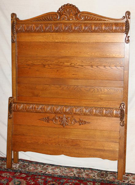 AMERICAN OAK HIGH-BACK BED C.1910, H 80", W 57": AMERICAN OAK HIGH-BACK BED, C. 1910, H 80", W 57":A high-back headboard and truncated footboard with shell and scroll motifs, with fitted rails.