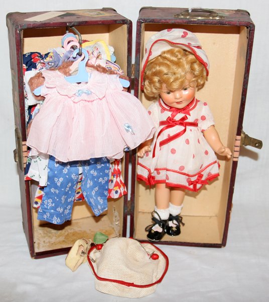 SHIRLEY TEMPLE DOLL 1936 + WARDROBE/CLOTHES: SHIRLEY TEMPLE DOLL BY IDEAL 1936, H 12" + WARDROBE AND CLOTHES:Case or wardrobe is 15" x 6 1/2". Doll is in good condition for age. Open/close eyes. Teeth.