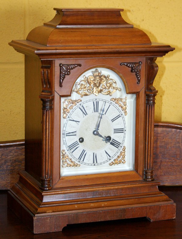 HAC GERMAN 14 DAY STRIKE MANTLE CLOCK, 20TH C: H.A.C. GERMAN 14 DAY STRIKE MANTLE CLOCK, 20TH C, H 16", W 11", D 8":having an inverted crown molding top, 3/4 fluted front corner columns, gilt mask trim to face with Roman numerals, two key wind, br