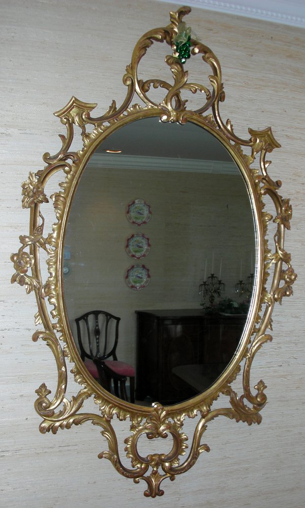 CARVED WOOD WITH GILT OVAL MIRROR, 60" X 36": GEORGIAN STYLE CARVED WOOD WITH GILT OVAL MIRROR, 60" X 36":Hand carved wood frame. No gesso. Probably Italian made. Circa 1950. From the Estate of Waldo A. Schaefer, M. D. Port Huron, Mi.