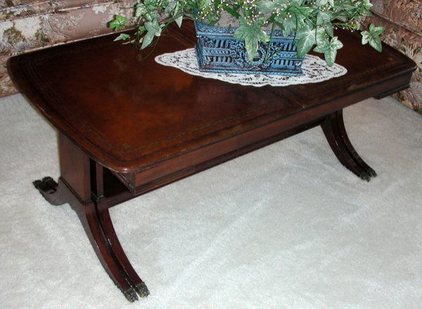 MAHOGANY COFFEE TABLE LEATHER TOP, H 15", L 40": MAHOGANY COFFEE TABLE, LEATHER TOP, H 15", L 40":Duncan Phyfe style. Table extends. Tooled leather top. Cigarette burn in leather. Circa 1950. W 21" From the Estate of Waldo A. Schaefer, M. D. Port Hu