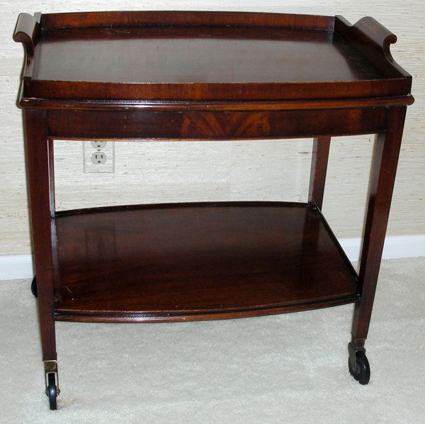 MAHOGANY TEA CART, H 25", L 26": MAHOGANY TEA CART, H 25", L 26":Separate tray top with wood gallery. Lower shelf. Circa 1940 - 50. On wheels. D 18". From the Estate of Waldo A. Schaefer, M. D. Port Huron, Mi.