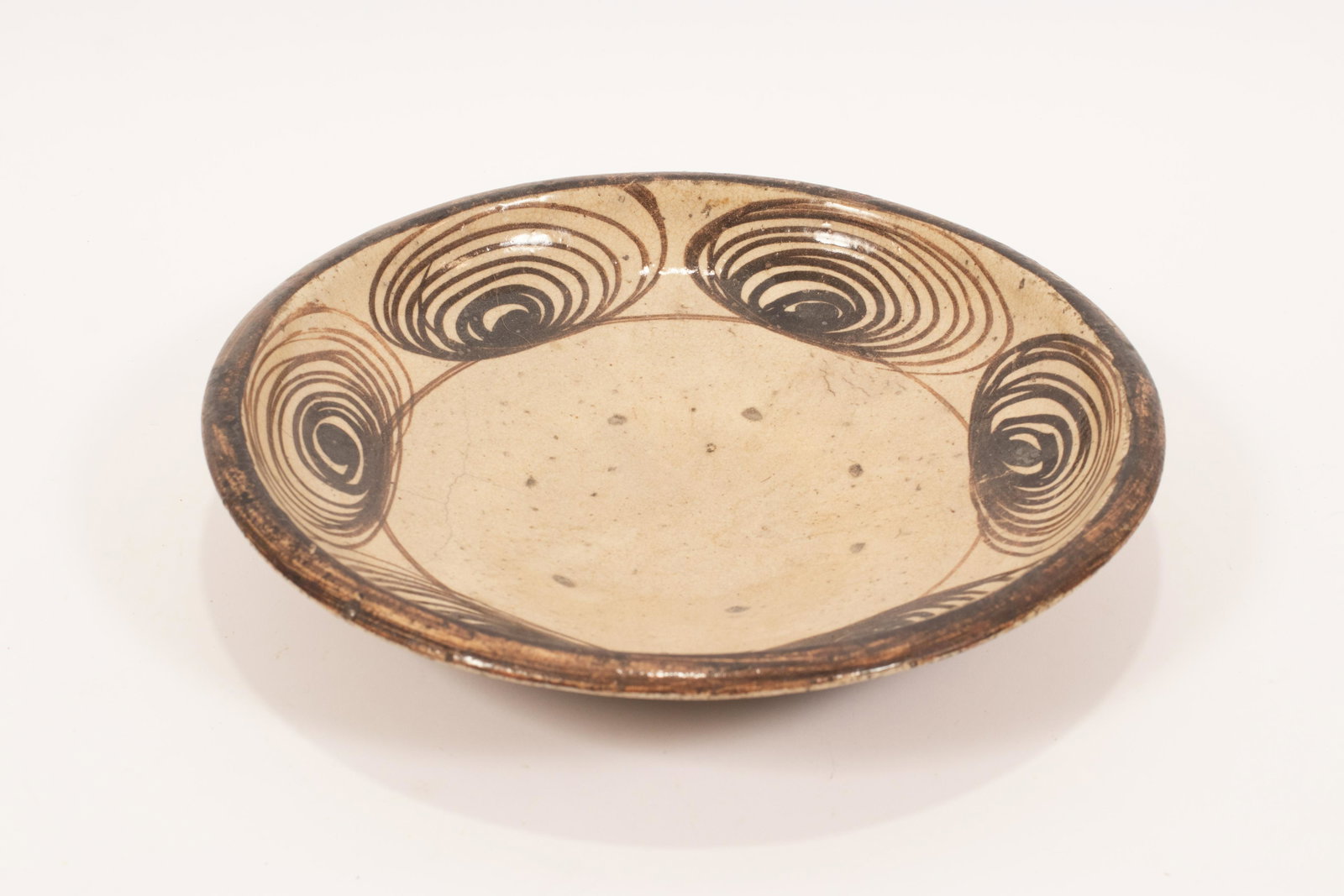 ISLAMIC EARTHENWARE BOWL 19TH C, H 2.5" DIA 13": ISLAMIC EARTHENWARE BOWL 19TH C, H 2.5" DIA 13" Spiral forms along the interior that form band. Indiscernible mark on underside. Provenance: Estate of Jack Faxon, Michigan Senator and creator of the M