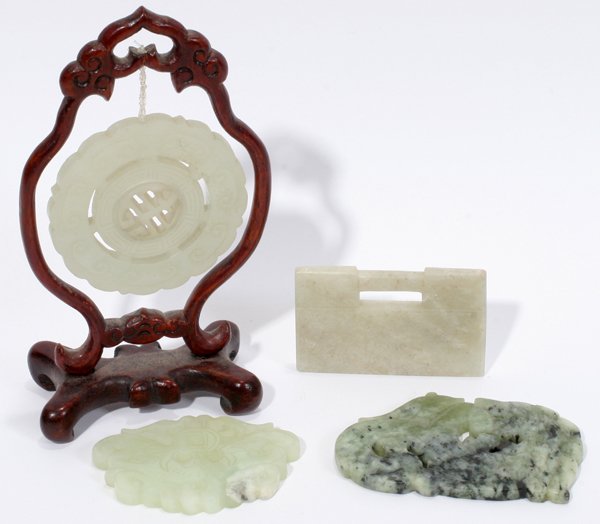 CHINESE JADE CARVINGS, FOUR, L 2"-3": CHINESE JADE CARVINGS, FOUR, L 2"-3":Including 1 disc with scalloped rim, light green color, Dia.2 1/4", suspended from a teakwood stand, H.5"; 2 carvings, one light green color with carved bat, L.2 3