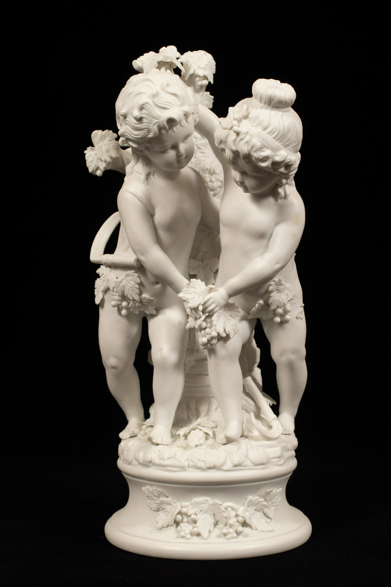 BISCUIT PORCELAIN FIGURAL GROUPING, H 13", DIA 6": BISCUIT PORCELAIN FIGURAL GROUPING, H 13", DIA 6"An unmarked biscuit porcelain figural grouping. Depicting two cherubs with grapevines. No markings.