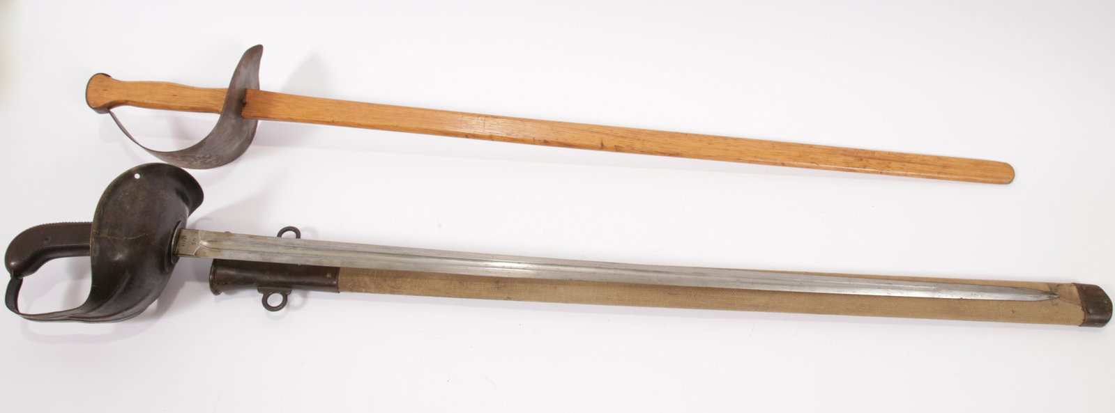 U.S. MODEL 1913 CAVALRY SABER "THE PATTON SABER", WITH: U.S. MODEL 1913 CAVALRY SABER "THE PATTON SABER", WITH PRACTICE SABER, 1914, TWO PCS., L 35" BLADE M1913 cavalry saber, designed by George Patton. Marked "SA" with a flaming bomb and dated 1914 on the