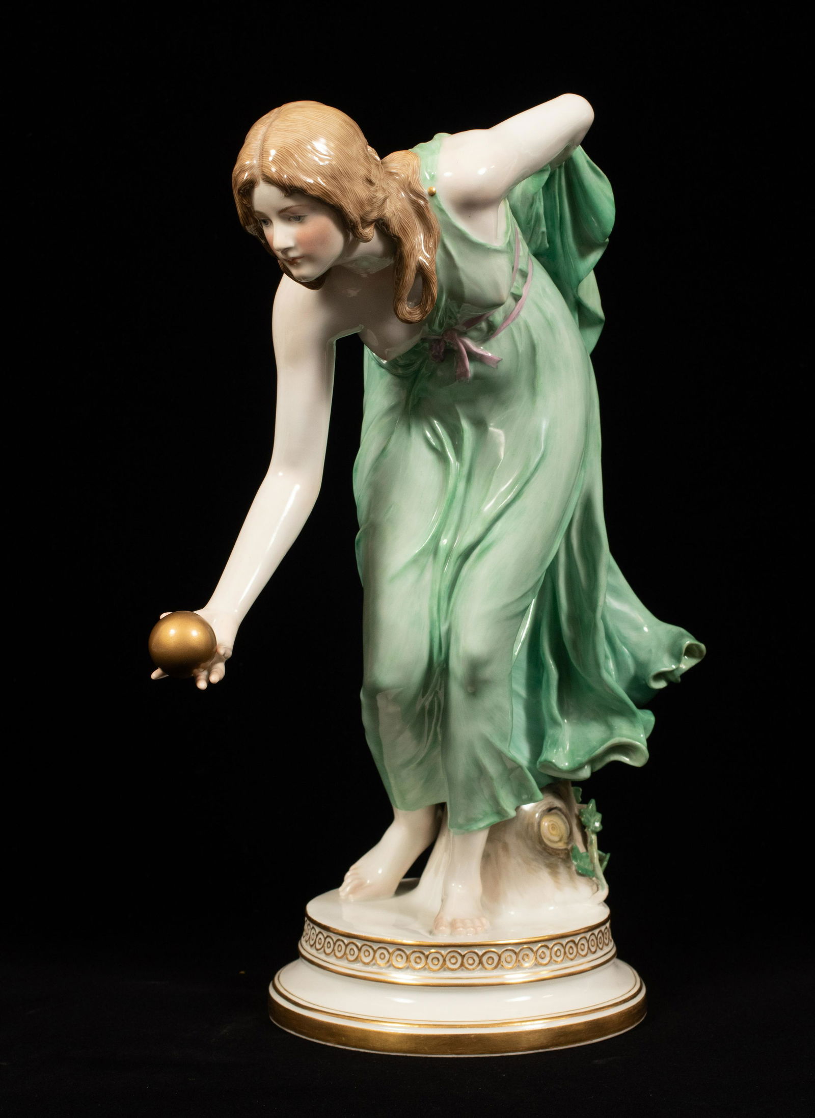 MEISSEN PORCELAIN SEMI NUDE WITH GOLDEN BALL H 14" D: MEISSEN PORCELAIN SEMI NUDE WITH GOLDEN BALL H 14" D 10" MODELED BY WALTER SCHOTT Incised Q480, impressed 144. Large size, modeled as a female leaning against a naturalistic stump; she is bent over wi