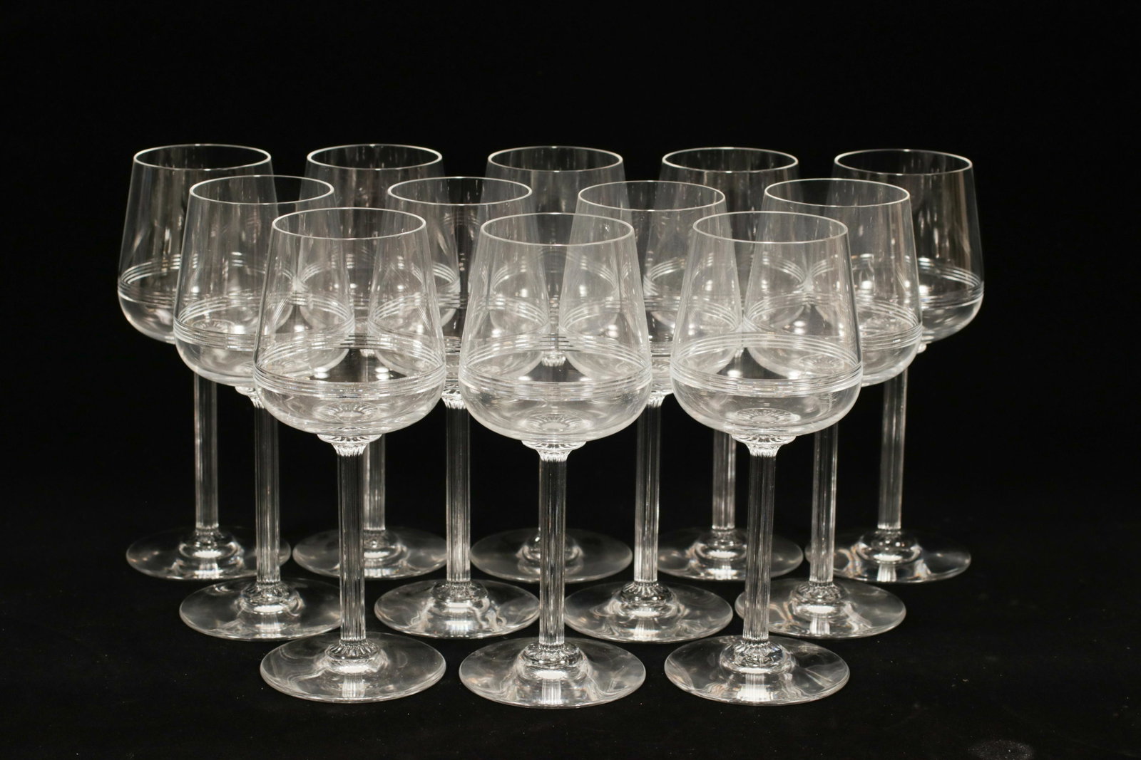 BACCARAT 'ATHENA' CRYSTAL RED WINES, 12 PCS, H 7.25": BACCARAT 'ATHENA' CRYSTAL RED WINES, 12 PCS, H 7.25" A set of twelve Baccarat 'Athena' crystal red wine glasses. This pattern offers a ribbed stem and cut horizontal linear bands to the chalice. Each 
