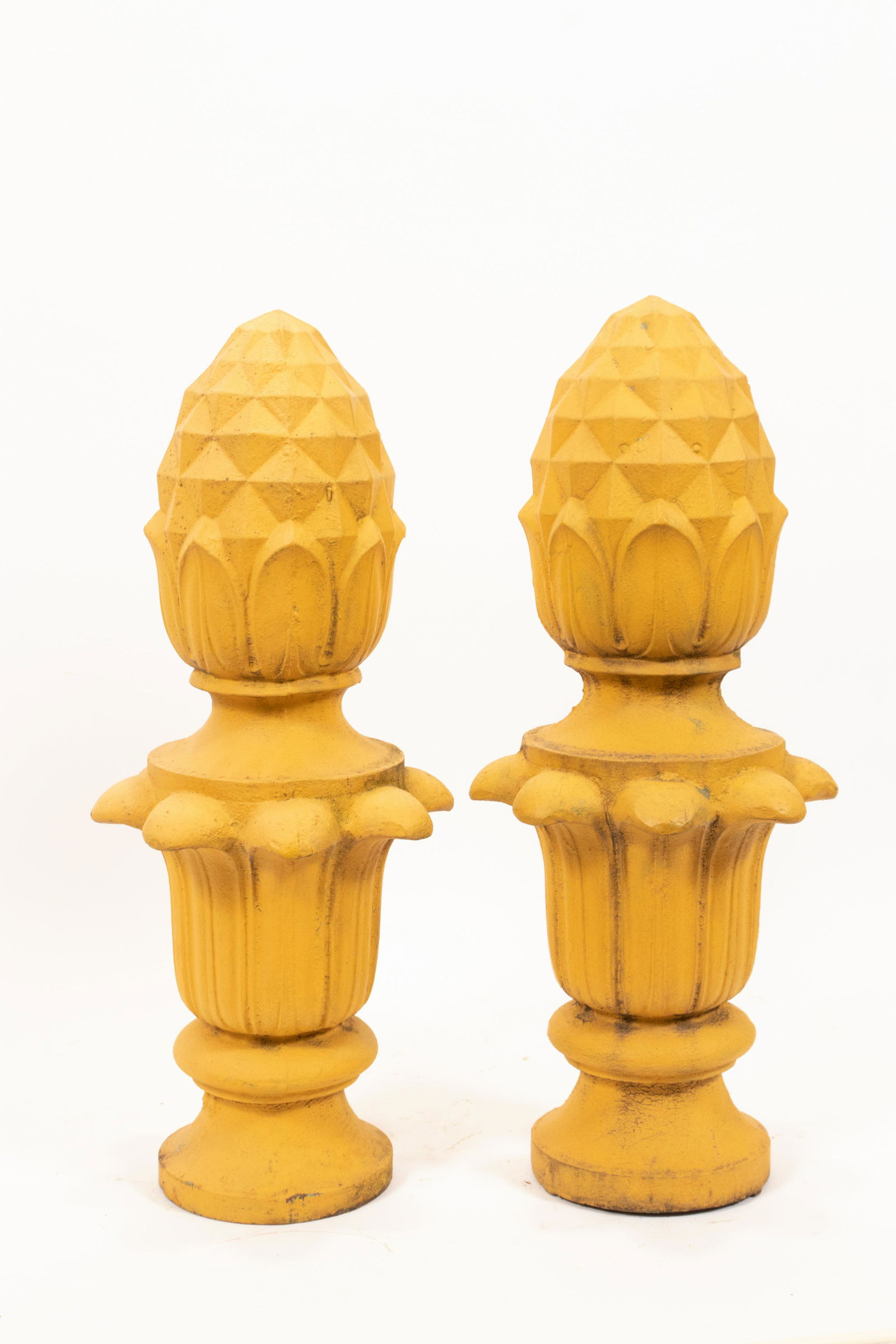 PAINTED IRON ACORN FINIALS, PAIR, H 21", DIA 9": PAINTED IRON ACORN FINIALS, PAIR, H 21", DIA 9" A pair of painted iron acorn finials. Having a bright maize tone. Provenance: Estate of Jack Faxon, Michigan Senator and creator of the Michigan Council