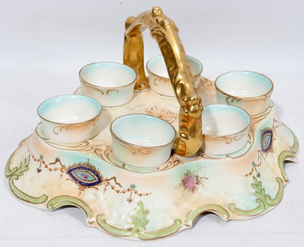 S.F. & CO. ENGLISH PORCELAIN EGG CUPS AND TRAY: S.F. & CO. ENGLISH PORCELAIN EGG CUPS AND TRAY, C:six egg cups having fired gold rims, pedestal bases and nest in holes in oval shape carry tray having fired gold handle and hand painted enamel medall