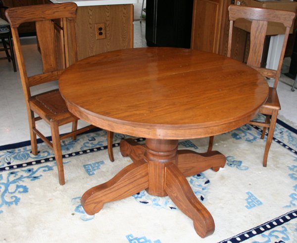 ROUND OAK DINING TABLE AND TWO CHAIRS, 3 PCS.,: ROUND OAK DINING TABLE AND TWO CHAIRS, 3 PCS., H 28", DIA 42":having a turned and octagonal pedestal base with four legs; two oak chairs with leather and hob nail trim seats; contoured center back spl