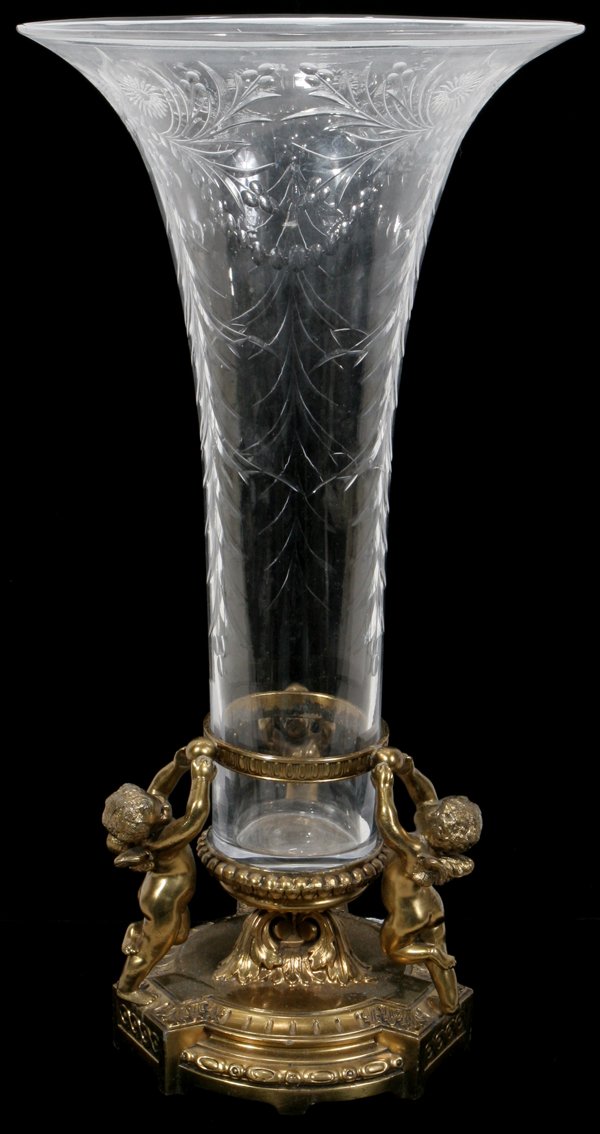 PAIRPOINT CRYSTAL & METAL FIGURAL VASE, H 14": PAIRPOINT CRYSTAL & METAL FIGURAL VASE, H 14", C. 1940:An etched crystal trumpet-form vase fitted in gilt metal frame featuring three cherubs, stamped "Pairpoint C 1532" with logo at the underside.