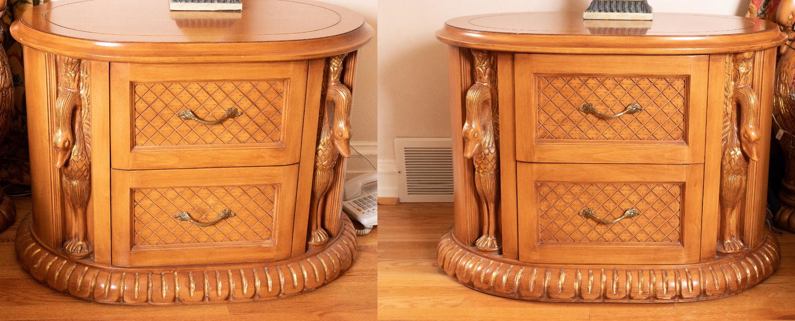 PHYLLIS MORRIS, SWAN DETAIL WALNUT 2-DRAWER TABLES,: PHYLLIS MORRIS, SWAN DETAIL WALNUT 2-DRAWER TABLES, PAIR H 23", W 32", D 21" Oval form. Curved fronts with carved swan detail, gadroon detail at base. Two drawers. From a Grosse Pointe Shores estate.