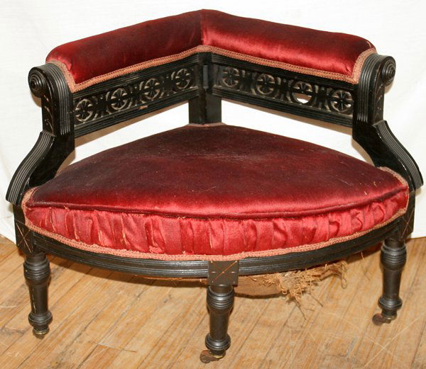 CORNER CHAIR, C. 1880, H 24": CORNER CHAIR, C. 1880, H 24":Red upholstery and wood casters. Measurements from front to back: 23", sides: 20", front: 29"