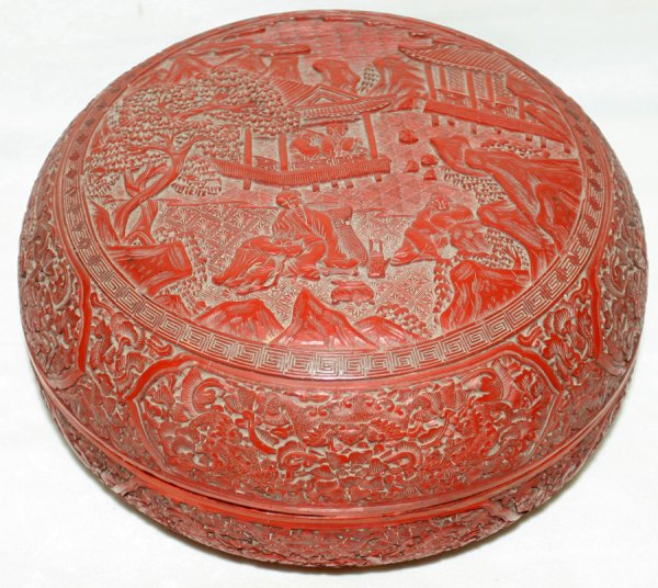CHINESE CARVED CINNABAR BOX, 19TH C., DIA 10": CHINESE CARVED CINNABAR BOX, 19TH C., DIA 10":Circular box carved at the cover with scholars in the landscape, floral motif overall. Measures H.5 1/2", Dia.10". From the Estate of David Steinman, Bloo