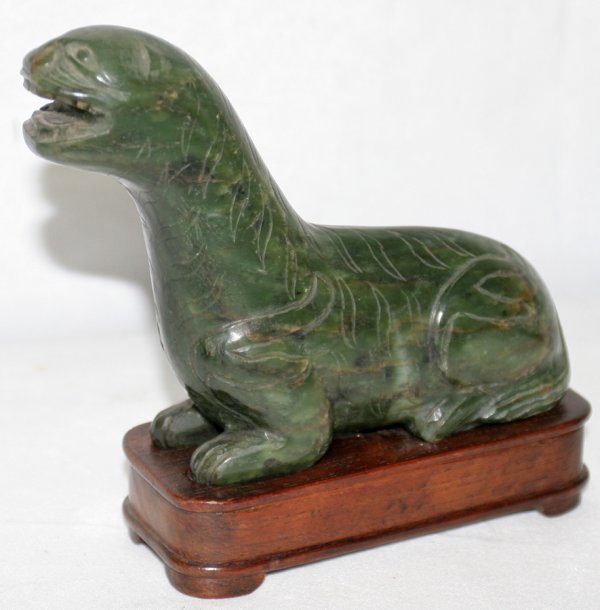 CHINESE GREEN HARD STONE FIGURE OF A SEAL, : CHINESE GREEN HARD STONE FIGURE OF A SEAL, H 4 3/4", L 6":Includes a wood base. From the Estate of David Steinman, Bloomfield Hills, Michigan.